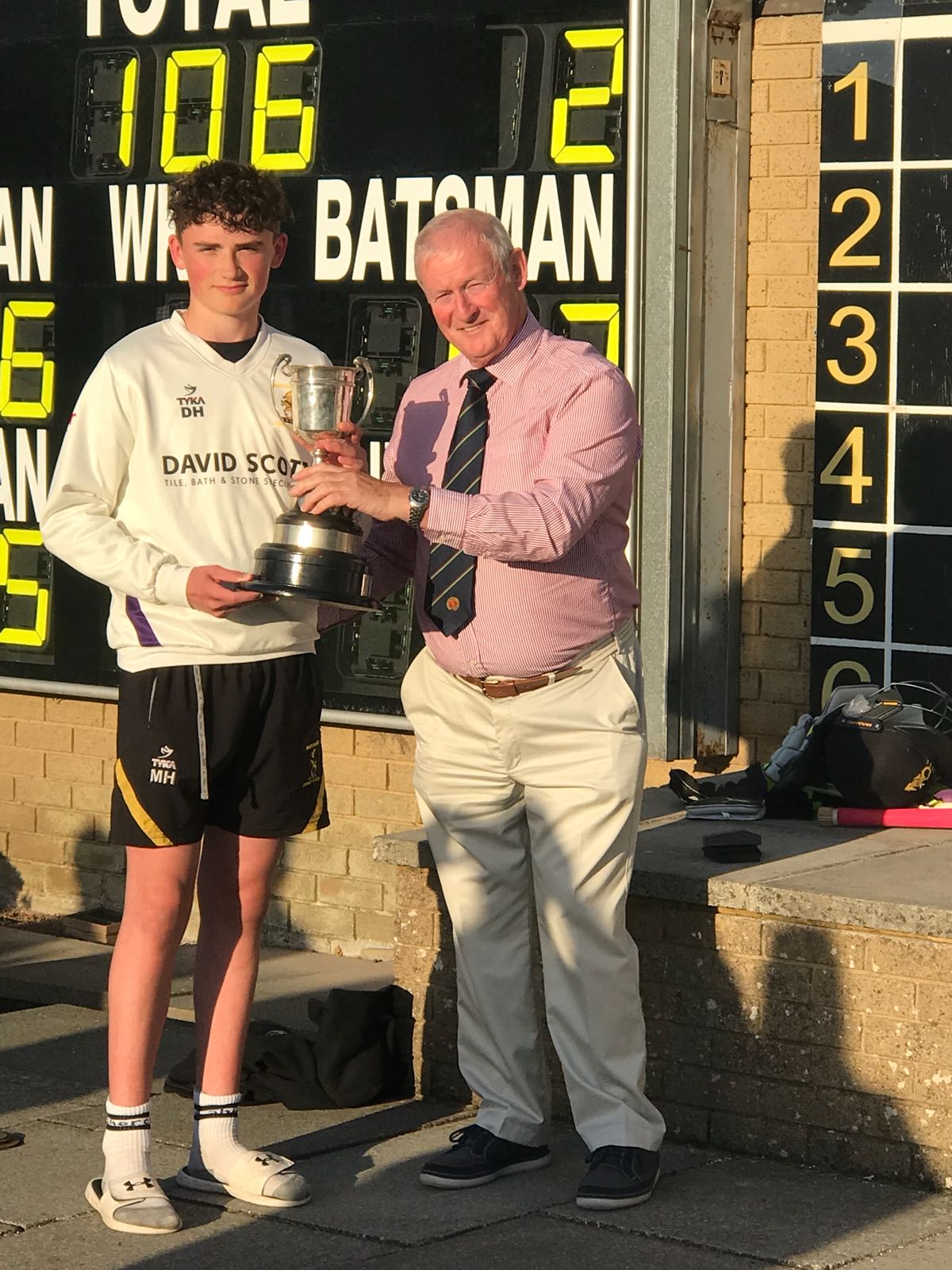 Instonians U 15 captain Matthew Humphreys receives the Graham Cup from NCU President Clarence Hiles